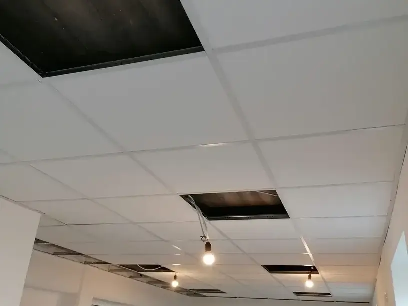 Abgeh&auml;ngte Modul- und Rasterdecke in Gewerberaum w&auml;hrend der Montage von Beleuchtung